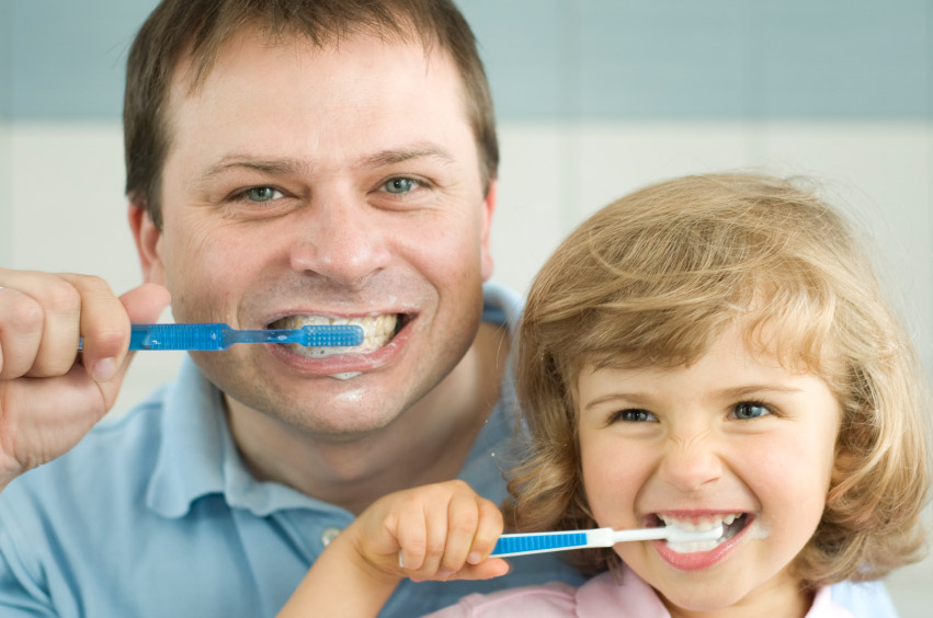 father and daughter brushing teeth
